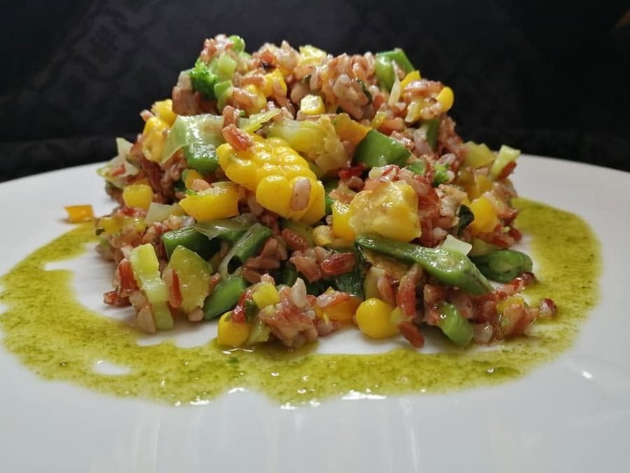 Insalata di riso rosso con mais, zucchine, asparagi e broccoli, condita con olio al basilico
